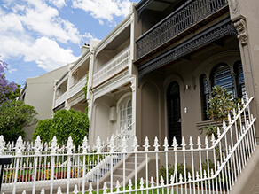 Brown Neutral Townhouse with Black Fencing and Fretwork with Black Door and Garden